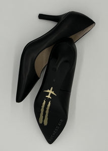 Classic black pump with a golden airplane image stamped against black outsole.