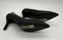 Load image into Gallery viewer, Classic black pump with a golden airplane image stamped against black outsole.
